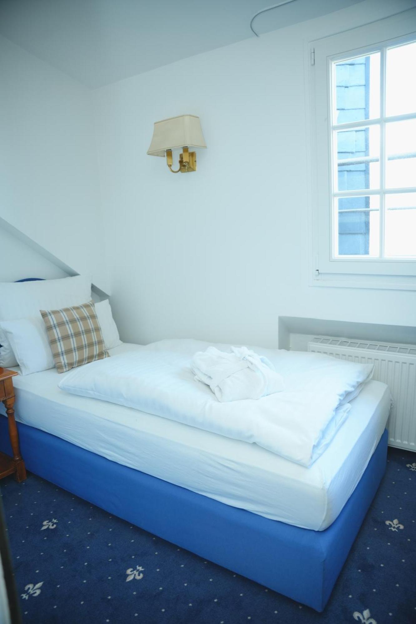 Einzelzimmer mit Bademantel und eigenem externen Badezimmer