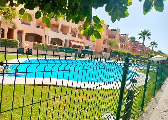 Bajo con jardín a pie de playa y piscina comunitaria con jacuzzi